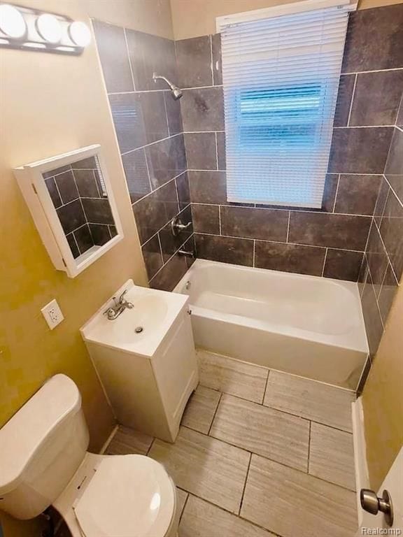 bathroom featuring toilet and tiled shower / bath combo