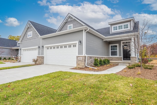 craftsman house with a garage and a front lawn