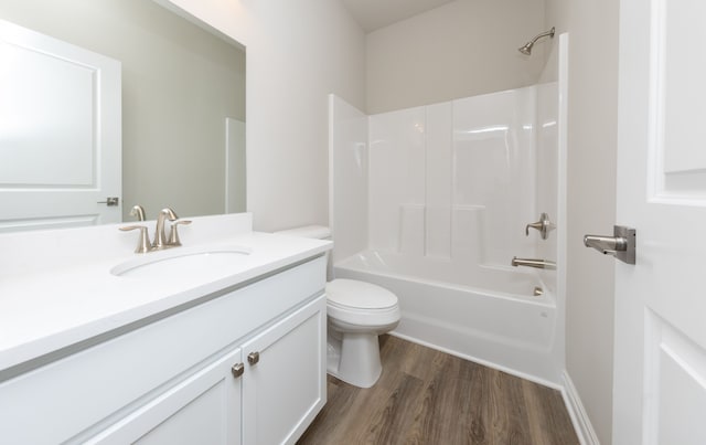 full bathroom featuring toilet, hardwood / wood-style flooring, washtub / shower combination, and vanity