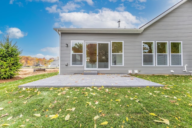 rear view of house with a patio and a lawn