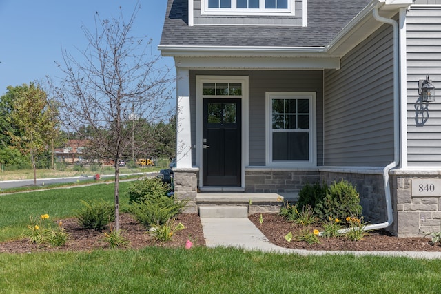 view of exterior entry featuring a lawn