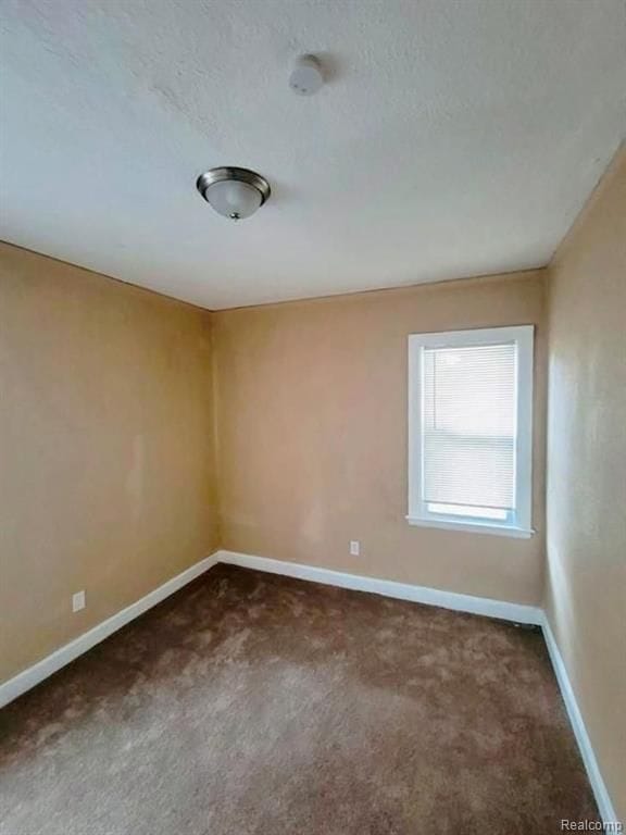 carpeted spare room with a textured ceiling