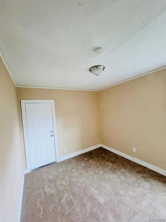 carpeted empty room featuring a textured ceiling