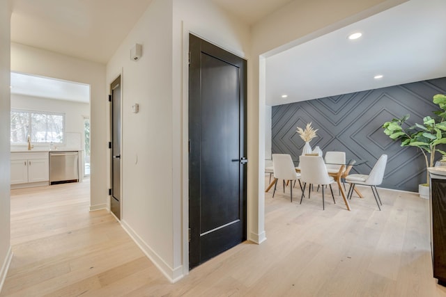 hall with sink and light hardwood / wood-style flooring