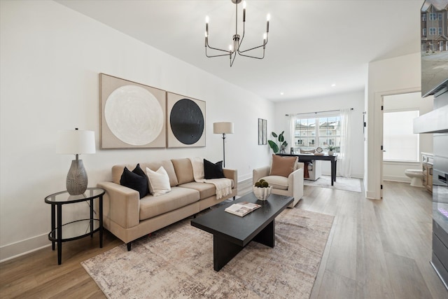 living room featuring a chandelier and light hardwood / wood-style flooring