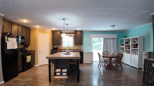 kitchen featuring black appliances, a center island, dark wood-type flooring, sink, and decorative light fixtures