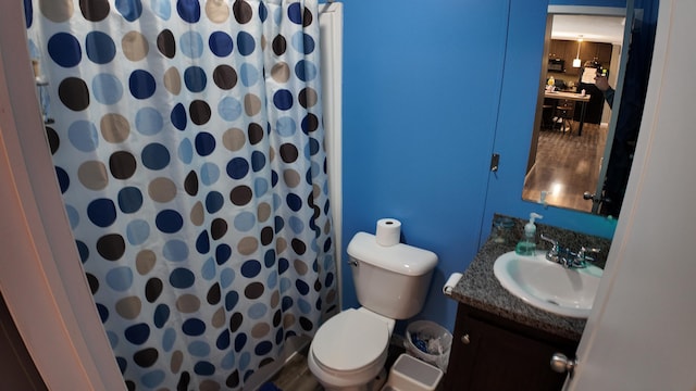 bathroom featuring vanity, curtained shower, and toilet