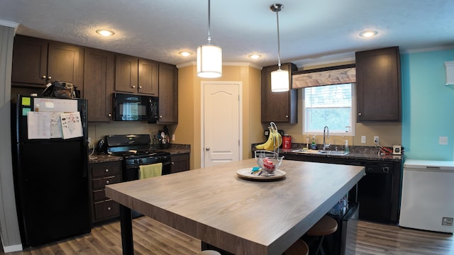 kitchen featuring sink, dark brown cabinetry, dark hardwood / wood-style floors, black appliances, and crown molding