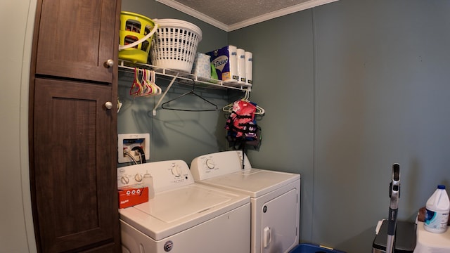 clothes washing area featuring a textured ceiling, washing machine and dryer, and ornamental molding