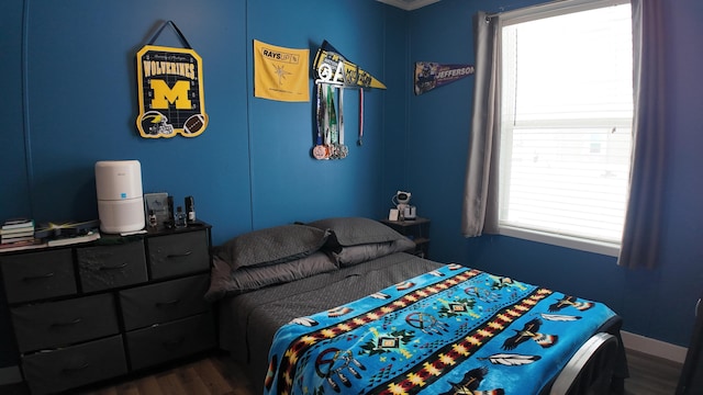 bedroom with ornamental molding and dark hardwood / wood-style floors