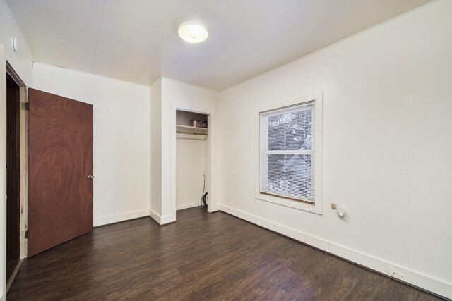 unfurnished bedroom featuring a closet and dark hardwood / wood-style floors