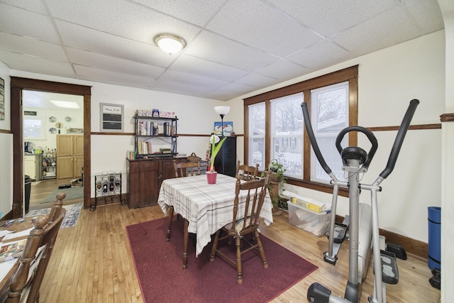 dining space with a paneled ceiling and wood-type flooring