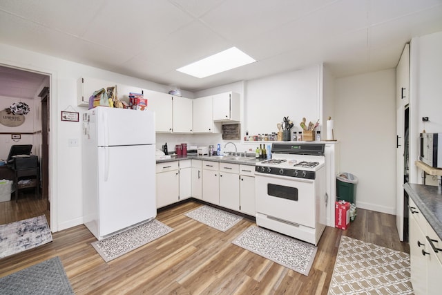 kitchen with sink, white appliances, white cabinetry, and light hardwood / wood-style flooring