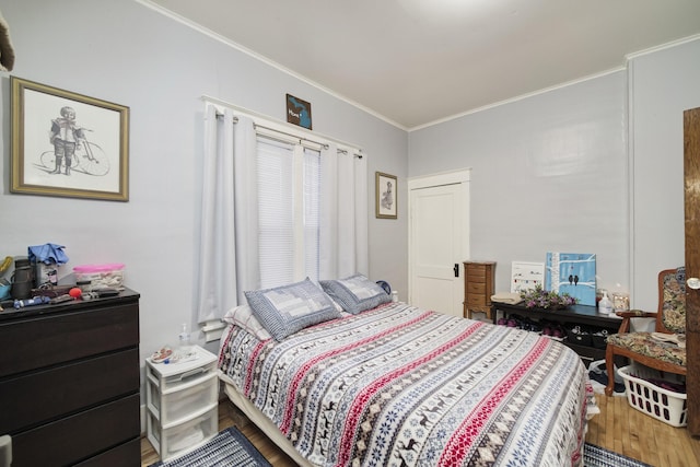 bedroom with hardwood / wood-style floors and ornamental molding