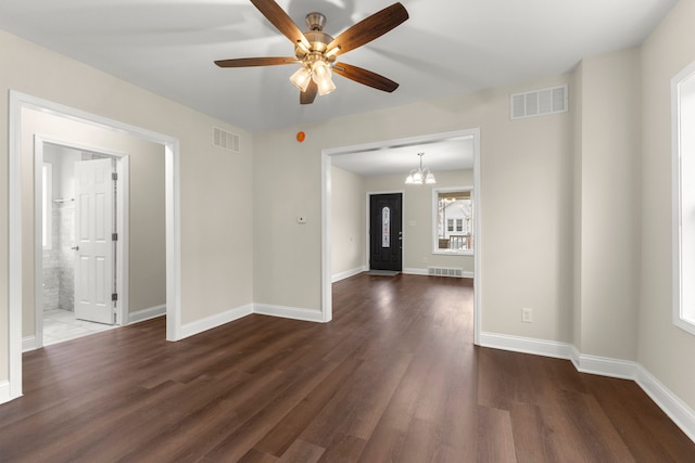 spare room featuring ceiling fan with notable chandelier and dark hardwood / wood-style floors