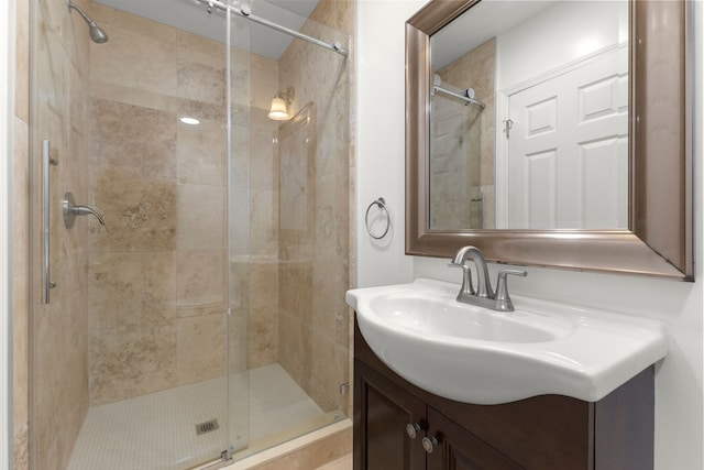 bathroom featuring a shower with door and vanity