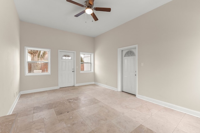 entryway with ceiling fan and baseboards