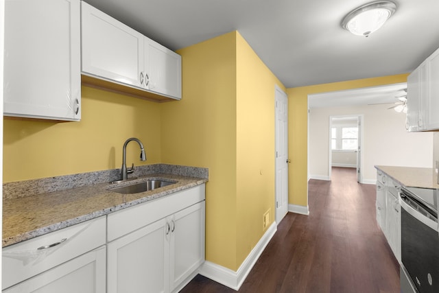 kitchen featuring dark wood-type flooring, stainless steel electric range, white cabinets, ceiling fan, and sink