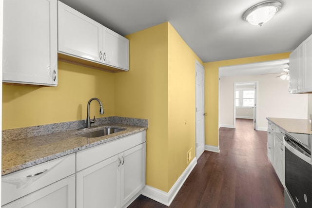kitchen with a sink, baseboards, white cabinets, and dark wood finished floors