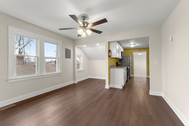 unfurnished living room with a ceiling fan, baseboards, visible vents, and dark wood-type flooring