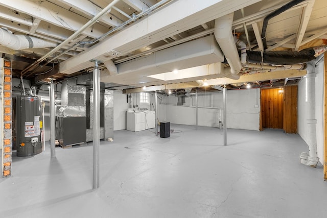 basement featuring separate washer and dryer, heating unit, and water heater