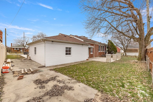 back of property featuring a fenced backyard, a patio, a lawn, and roof with shingles