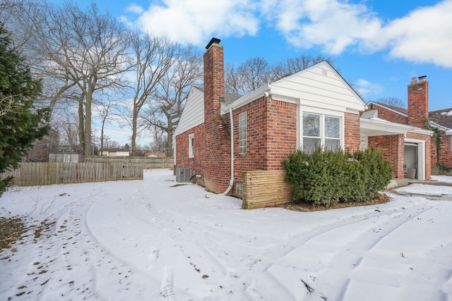 view of snow covered exterior with central AC unit