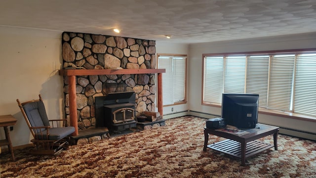 living room featuring a textured ceiling, a wood stove, and a baseboard heating unit