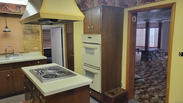 kitchen with island exhaust hood, white double oven, cooktop, a kitchen island, and sink