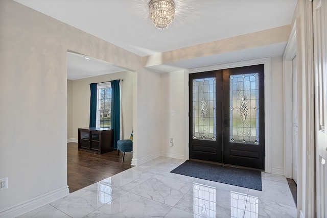 entryway with french doors and a notable chandelier