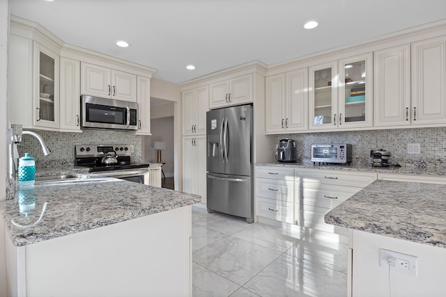 kitchen featuring stainless steel appliances, decorative backsplash, sink, and light stone counters