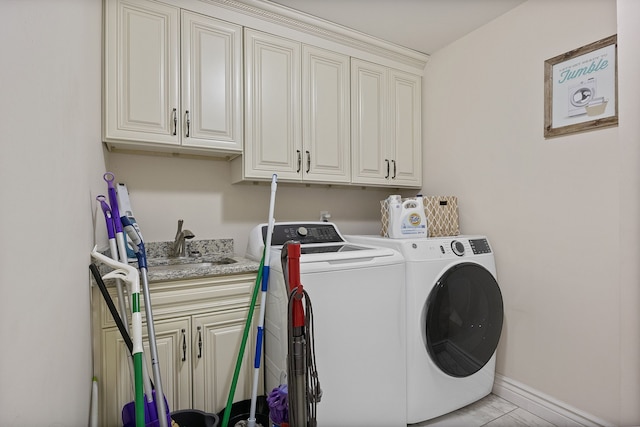 laundry area with separate washer and dryer, cabinets, and light tile patterned flooring