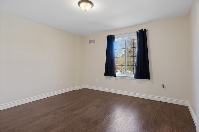 spare room featuring dark wood-type flooring