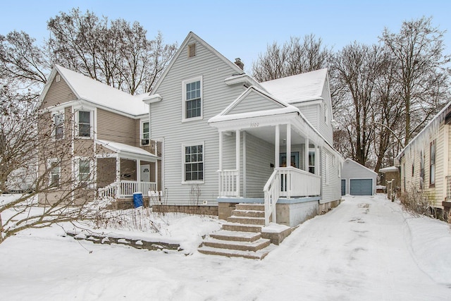 front of property with covered porch, a garage, and an outdoor structure