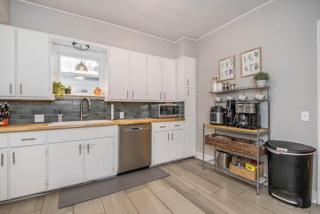 kitchen with stainless steel appliances, white cabinetry, sink, and tasteful backsplash