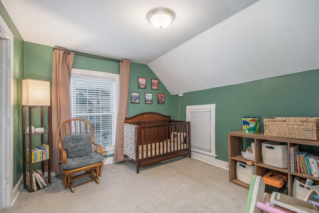 carpeted bedroom with lofted ceiling and a crib