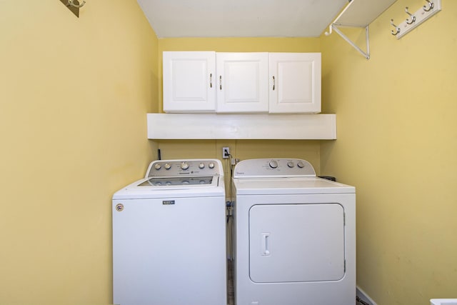 laundry area with washer and dryer and cabinets