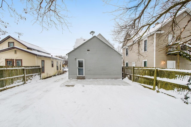 view of snow covered back of property