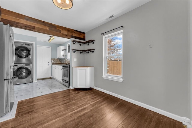 washroom with light hardwood / wood-style floors and stacked washer / dryer