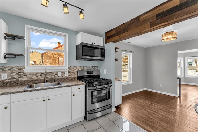 kitchen with tasteful backsplash, stainless steel appliances, sink, and white cabinets