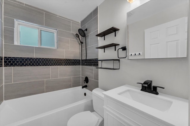 full bathroom featuring tiled shower / bath, vanity, and toilet