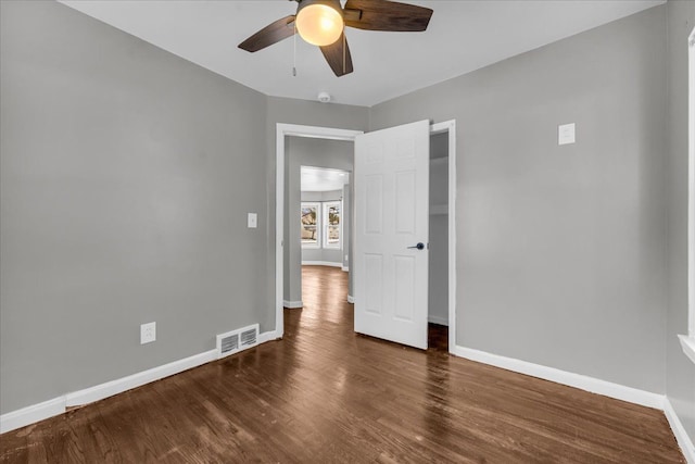 empty room featuring dark wood-type flooring and ceiling fan