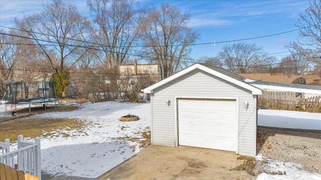 snow covered garage featuring a trampoline