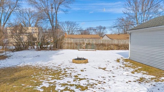 snowy yard featuring a fire pit