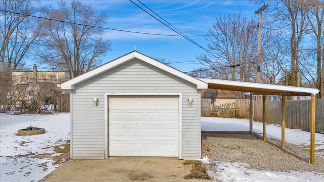 snow covered garage featuring a carport