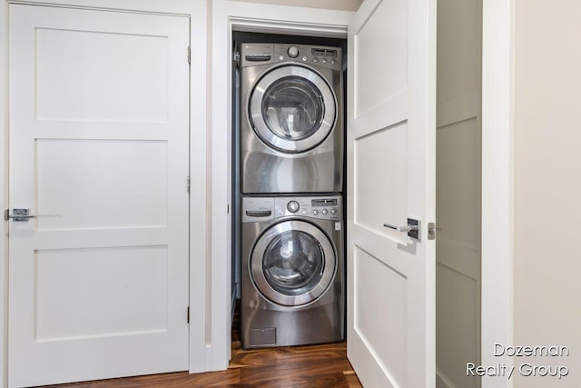 clothes washing area with stacked washing maching and dryer and dark hardwood / wood-style floors