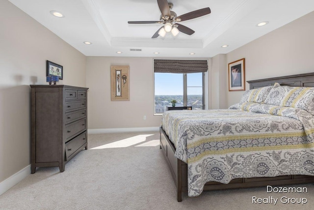 bedroom with ceiling fan, light colored carpet, a raised ceiling, and crown molding