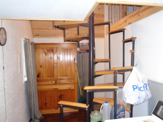 interior space featuring lofted ceiling and wood walls