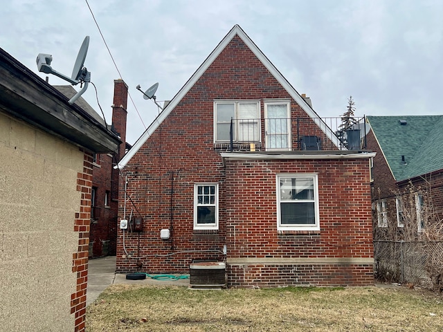 back of house with central AC unit and a yard