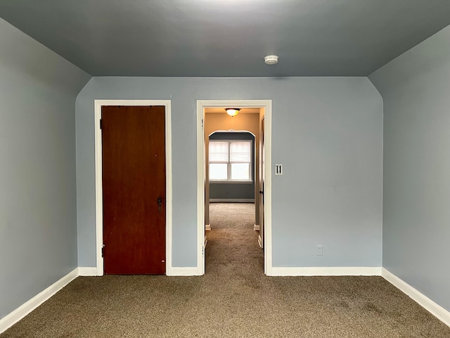 interior space featuring vaulted ceiling and carpet